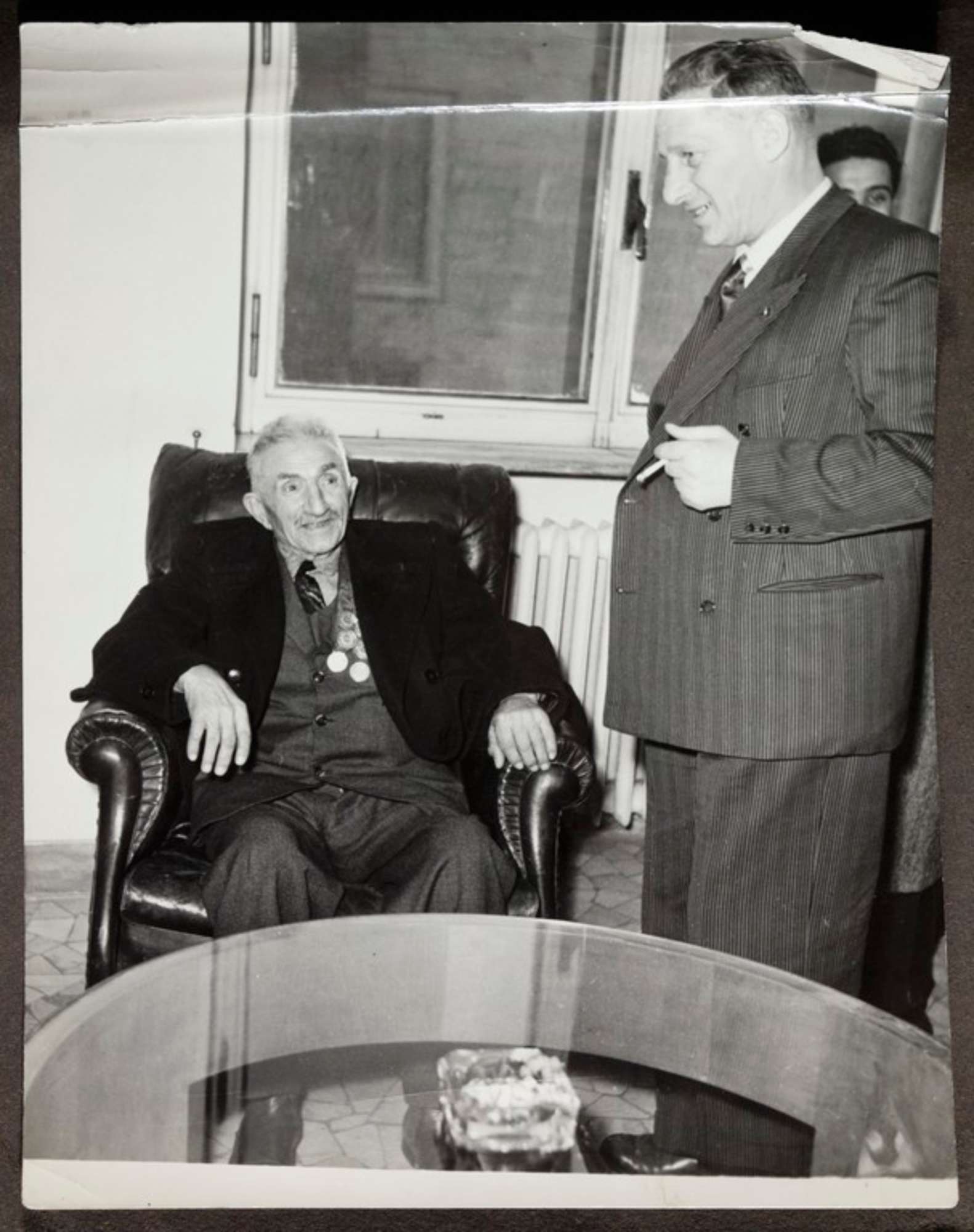 Sede bolognese del Partito Socialista Italiano (?), Alcide Cervi in visita conversa con un ospite